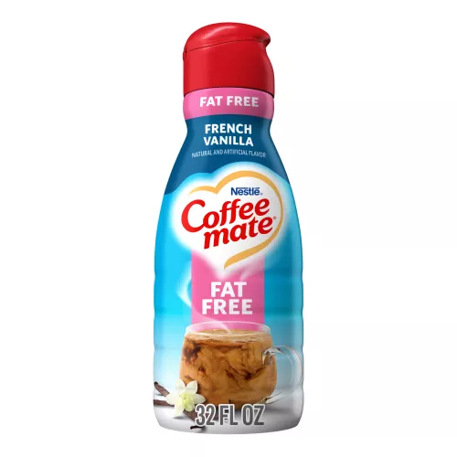 A bottle of French Vanilla Liquid Creamer with a red cap and pink "Fat Free" label above a mug and vanilla beans.