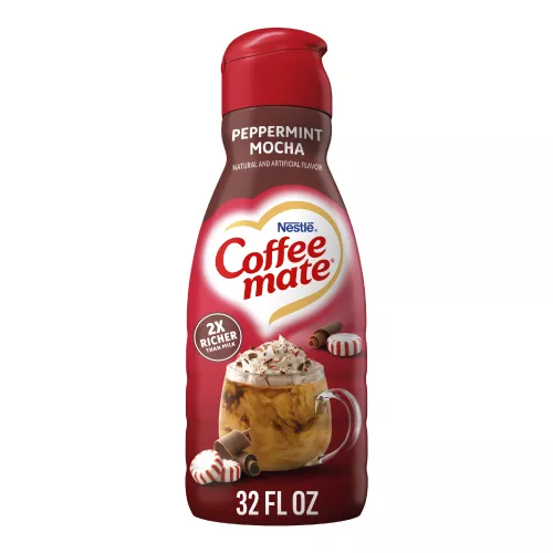 Una botella roja de creamer Peppermint Mocha con una taza de café, trozos de chocolate y trocitos de menta debajo del logotipo de Coffee mate.