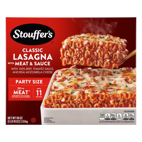 Una espátula saca Lasagna with Meat & Sauce de una fuente roja sobre una mesa con el nombre del producto y una etiqueta que dice "el doble de carne".
