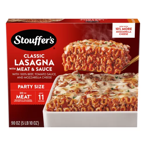 A spatula lifts Lasagna with Meat & Sauce from a red dish on a table with the product name and "2x the Meat" label.