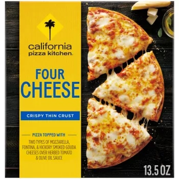 Box of Four Cheese Pizza with half a pizza, oil and blocks of parmesan on a black wooden surface.