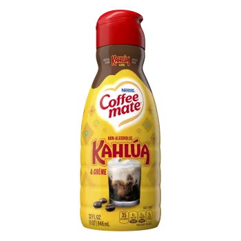 Una botella amarilla de creamer sabor Kahlúa & Créme con el logo de Kahlúa sobre un vaso de café con crema.