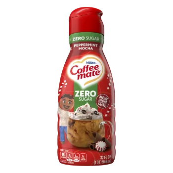 A bottle of Zero Sugar Peppermint Mocha creamer with a green label above a candy cane striped mug and chocolate chunks.