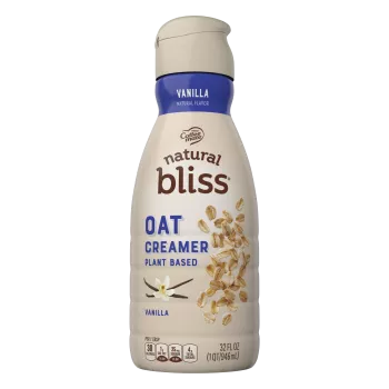 Botella marrón de Vanilla Flavored Oat Milk Creamer de natural bliss con una etiqueta azul sobre vainilla y avena.