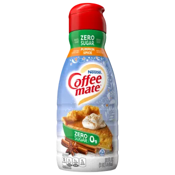 A bottle of Zero Sugar Pumpkin Spice creamer with a green label above a slice of pumpkin pie and cinnamon sticks.