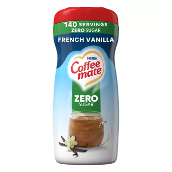 A blue canister of French Vanilla Creamer with a red cap and green “Sugar Free” label above a coffee mug and vanilla beans.