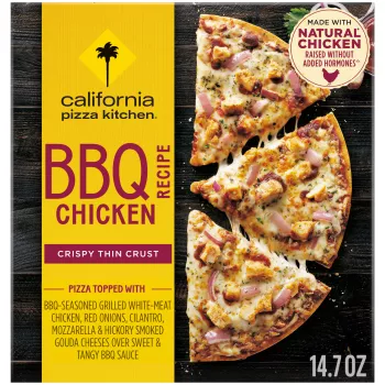 Box of BBQ Chicken Pizza with half a pizza, assorted toppings and the natural chicken badge on a black wooden surface.