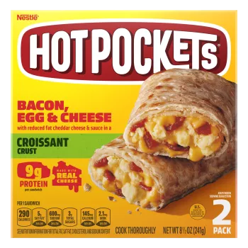 Una caja amarilla de Bacon, Egg & Cheese Hot Pockets con un sándwich con corteza de croissant sobre una etiqueta verde.