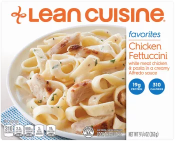 A box of Chicken Fettuccini with a favorites label near a bowl of fettuccini and chicken covered with alfredo sauce.