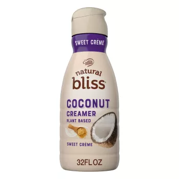 A beige bottle of natural bliss Coconut Milk Sweet Crème Creamer with a purple label above the product name and a coconut.