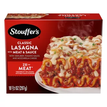 A plate of Lasagna with Meat & Sauce on a table below the product name, STOUFFER'S logo and "2x the Meat" label.