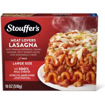 Un plato de Meat Lovers Lasagna sobre una mesa debajo del nombre del producto, una etiqueta que dice tamaño grande, el logo de STOUFFER'S y una etiqueta que dice "17 g de proteína".