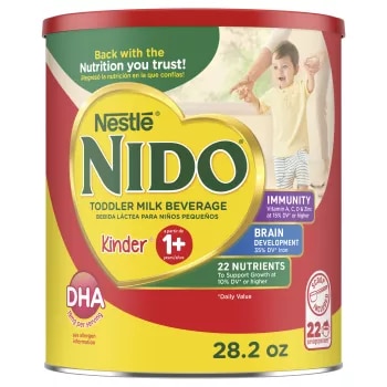 Una lata de Nido 1+ con una insignia que dice "inmunidad, vitaminas A, C y D, hierro y zinc" cerca de un niño que aplaude.