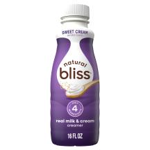 A white bottle of natural bliss Sweet Cream Creamer with a purple label above dairy pitchers and the product name.