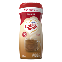 Una lata de creamer en polvo Coffee mate Original con una tapa roja y una etiqueta roja encima de una taza de café y un biscotti.
