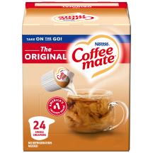Una caja de porciones individuales de creamer original Coffee mate con una etiqueta roja, una taza de café, un biscotti y el logotipo de Coffee mate.