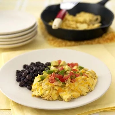 Fotografía: huevos revueltos con pico de gallo y frijoles negros en plato blanco
