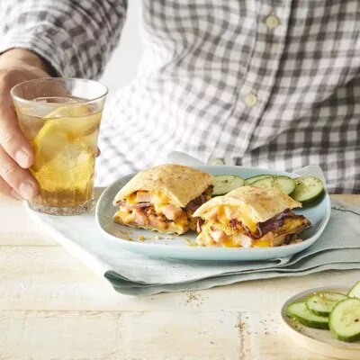 Foto: quesadilla partida con queso y carne, rodajas de pepino y vaso con bebida
