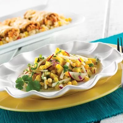 Fotografía: ensalada de maíz con rábano y cilantro en plato blanco