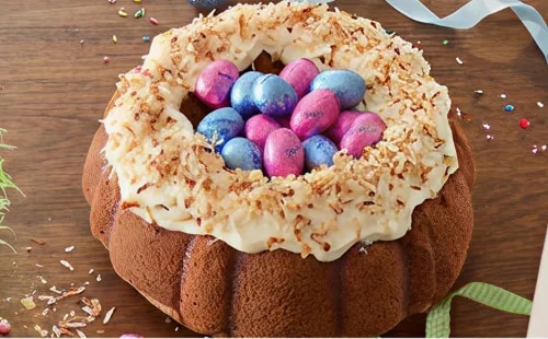 Photo: bundt cake with white frosting, toasted coconut and pastel metallic eggs
