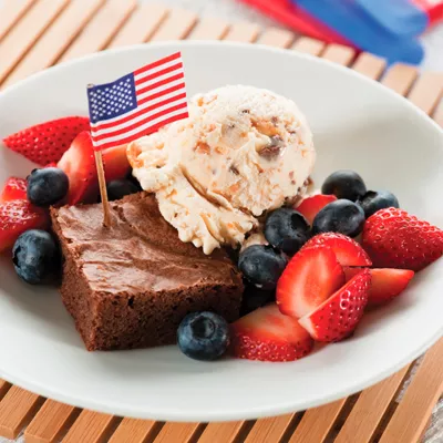 Foto: brownie con helado, fresas, arándanos y banderita estadounidense