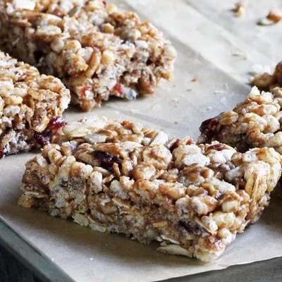 Fotografía de barras de granola con avena, nueces y arándanos secos sobre papel