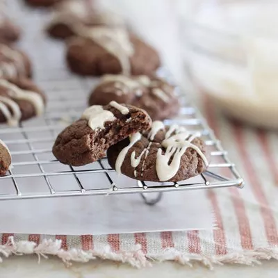 Fotografía de galletas de chocolate con relleno y glaseado blanco sobre rejilla