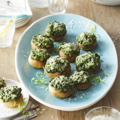 Fotografía de champiñones rellenos de espinaca y queso en plato azul