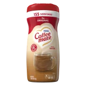 Una lata de creamer en polvo Coffee mate Original con una tapa roja y una etiqueta roja encima de una taza de café y un biscotti.
