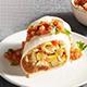 Breakfast burrito on a white plate.